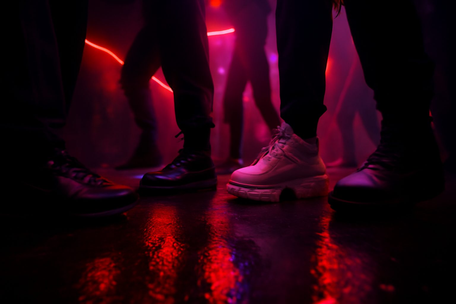 Paires de sneakers (Nike Air Max, Doc Martens, Buffalo, Palladium) qui dansent sur un dancefloor techno plongé dans la brume et les lasers